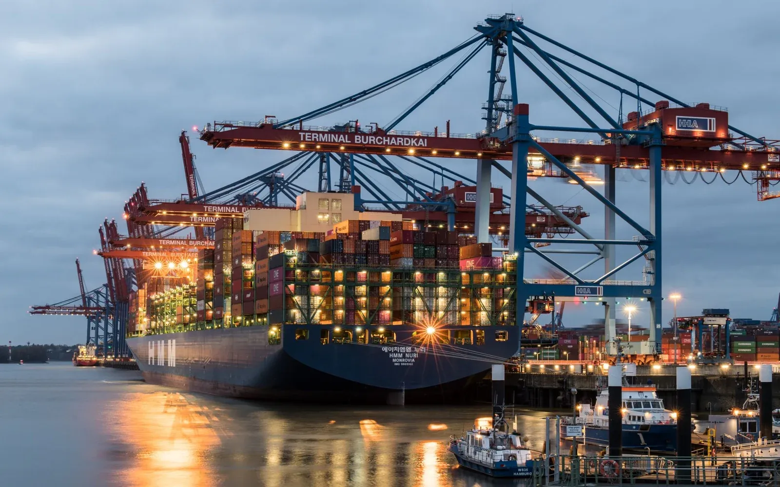 Container ship at a terminal used as contextual imagery for Meguis Import and Export